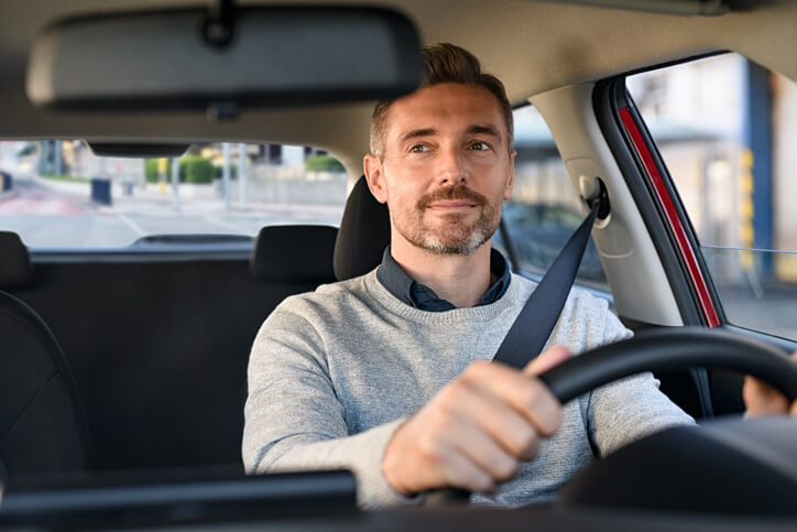 priecīgs vīrietis pie auto stūres